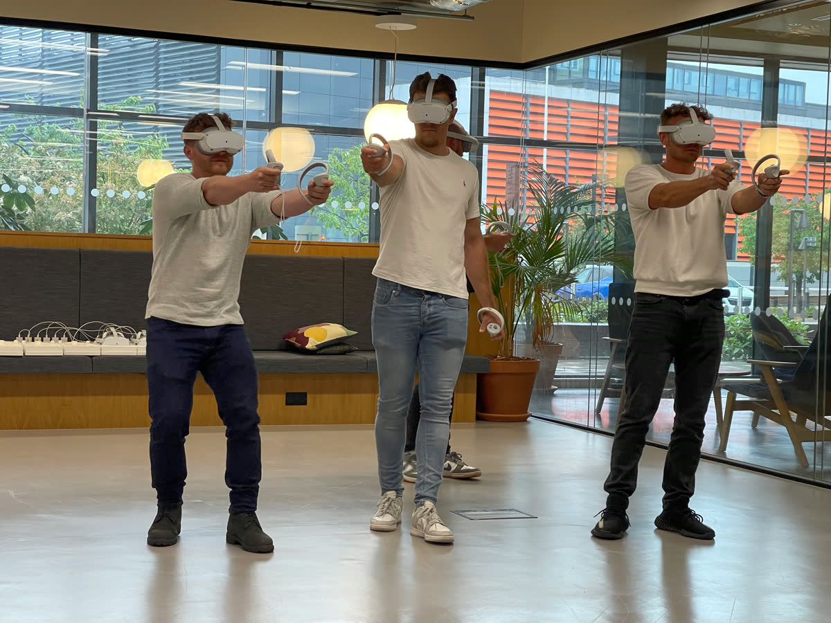 Three colleagues in VR headsets playing together